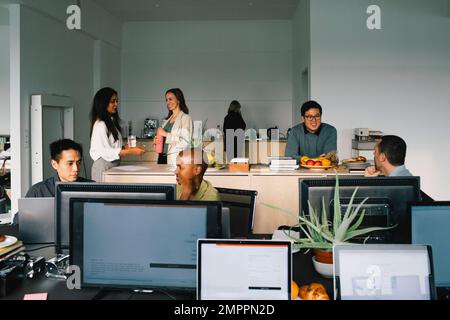 Multiracial corporate business colleagues communicating with each other at office Stock Photo