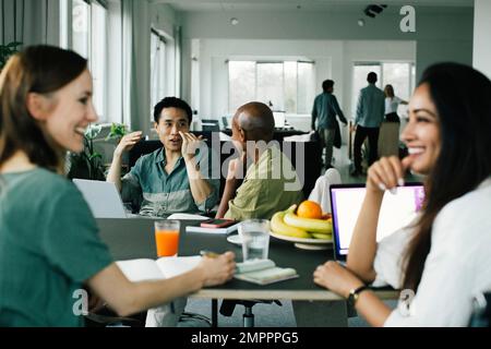 Business colleagues gesturing and talking to each other during meeting at office Stock Photo