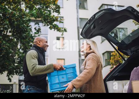 Low angle view of mature man giving crate to woman Stock Photo