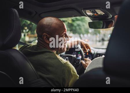 Smiling mature man looking away while sitting in car Stock Photo