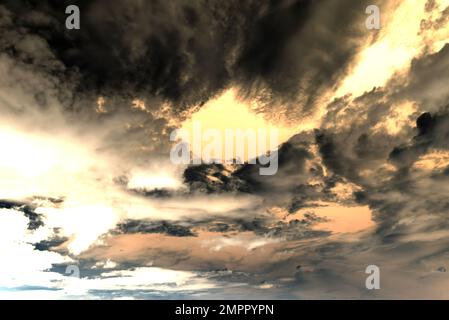 Abstract photography of clouds on a bright orange from the sun dark gloomy sky Stock Photo