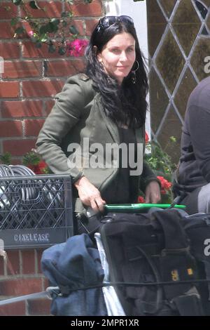 Courteney Cox looks to be wearing no makeup as she works on her script notes on the set of her feature directorial debut for Lifetime, 'Tall Hot Blonde.' Los Angeles, CA. 28th March 2012. Stock Photo