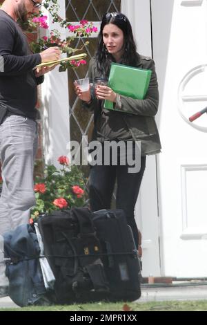 Courteney Cox looks to be wearing no makeup as she works on her script notes on the set of her feature directorial debut for Lifetime, 'Tall Hot Blonde.' Los Angeles, CA. 28th March 2012. Stock Photo