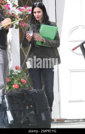 Courteney Cox looks to be wearing no makeup as she works on her script notes on the set of her feature directorial debut for Lifetime, 'Tall Hot Blonde.' Los Angeles, CA. 28th March 2012. Stock Photo