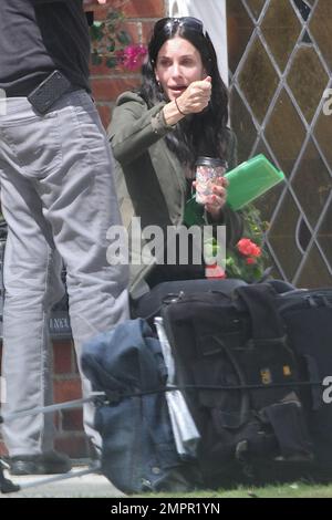 Courteney Cox looks to be wearing no makeup as she works on her script notes on the set of her feature directorial debut for Lifetime, 'Tall Hot Blonde.' Los Angeles, CA. 28th March 2012. Stock Photo