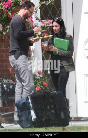 Courteney Cox looks to be wearing no makeup as she works on her script notes on the set of her feature directorial debut for Lifetime, 'Tall Hot Blonde.' Los Angeles, CA. 28th March 2012. Stock Photo