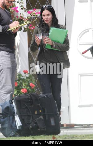 Courteney Cox looks to be wearing no makeup as she works on her script notes on the set of her feature directorial debut for Lifetime, 'Tall Hot Blonde.' Los Angeles, CA. 28th March 2012. Stock Photo