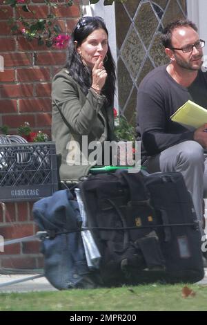 Courteney Cox looks to be wearing no makeup as she works on her script notes on the set of her feature directorial debut for Lifetime, 'Tall Hot Blonde.' Los Angeles, CA. 28th March 2012. Stock Photo