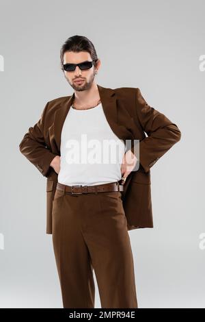 Stylish young man in suit and sunglasses isolated on grey Stock Photo