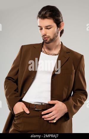 Stylish man in brown suit posing isolated on grey Stock Photo