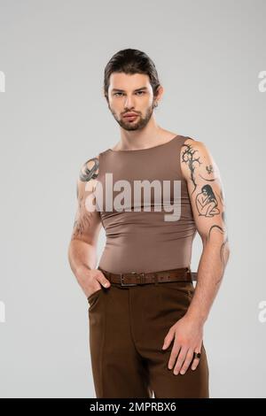 Stylish tattooed man in tank top posing isolated on grey Stock Photo