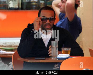 EXCLUSIVE!! UK singer Craig David strolls on Lincoln Road in South Beach, stopping outside a local cafe to check his cellphone. Wearing a black hoodie, shorts and high-top sneakers, David also stopped to have a drink with a friend at a bar along the popular pedestrian mall. Craig David will reportedly release a new album later this year. His most recent album, 'Signed Sealed Delivered,' hit stores in March 2010 and entered the UK Albums Chart at number 13. Miami Beach, FL. 1/3/11. Stock Photo