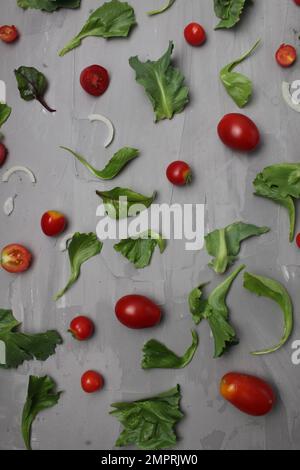 the background of a meal of tomato vegetables on a gray background. Tomatoes salad onions on a gray background. Diet. Stock Photo