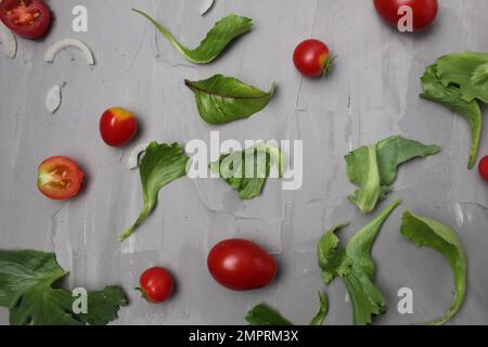 the background of a meal of tomato vegetables on a gray background. Tomatoes salad onions on a gray background. Diet. Stock Photo