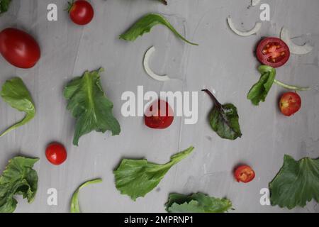 the background of a meal of tomato vegetables on a gray background. Tomatoes salad onions on a gray background. Diet. Stock Photo