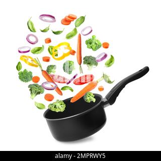 Many different ingredients falling into saucepan on white background. Delicious recipe Stock Photo