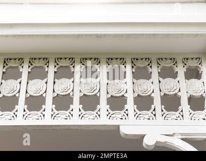 The wooden eaves with the flower stencil are decorated on the edge of the local house, front view for the background. Stock Photo