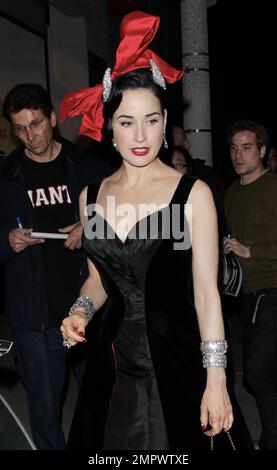 Wearing a black satin dress and accessorized with a red purse, red high heels and a giant red bow hat burlesque icon Dita Von Teese was seen leaving Perez Hilton's Mat Hatter Tea Party 34th Birthday Bash held at Siren Studios in Los Angeles, CA. 24th March 2012. Stock Photo