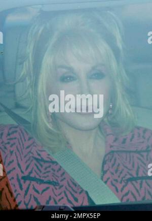 Busty country music legend Dolly Parton shows off her big smile while being driven around Bedford Drive. Los Angeles, CA. 04/19/10. Stock Photo