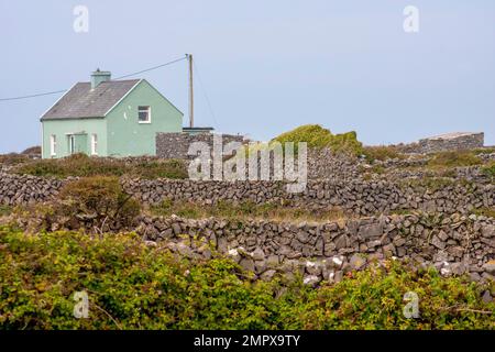 Rural Life Ireland a green-painted rural farmhouse in Ireland beside fields dry-stone walls on Irish island, Inishmore, Aran Islands, County Galway. Stock Photo
