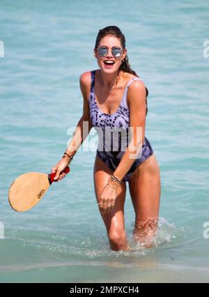 Doutzen Kroes is spotted playing paddle ball seaside with husband Sunnery James. They were joined by a friend and director Michael Bay. The 30 year old model looked amazing in a tiger print one piece swimsuit. Miami Beach, FL. March 30, 2015. Stock Photo