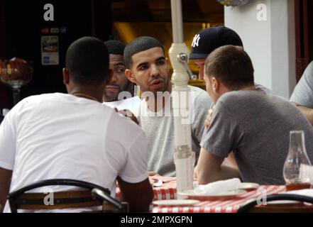 EXCLUSIVE!! Canadian actor and Grammy-nominated recording artist Drake (aka Aubrey Drake Graham) enjoys a meal with friends on Miami Beach while celebrating his 24th birthday during a trip to Miami. He was honored at a birthday bash sponsored by Grey Goose Vodka over the weekend, where he was named a Grey Goose Rising Icon. Drake's first studio album, 'Thank Me Later,' was released on June 15 and debuted at number one on the Billboard 200 chart. Miami Beach, FL. 10/25/10. Stock Photo