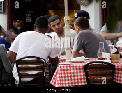 EXCLUSIVE!! Canadian actor and Grammy-nominated recording artist Drake (aka Aubrey Drake Graham) enjoys a meal with friends on Miami Beach while celebrating his 24th birthday during a trip to Miami. He was honored at a birthday bash sponsored by Grey Goose Vodka over the weekend, where he was named a Grey Goose Rising Icon. Drake's first studio album, 'Thank Me Later,' was released on June 15 and debuted at number one on the Billboard 200 chart. Miami Beach, FL. 10/25/10. Stock Photo