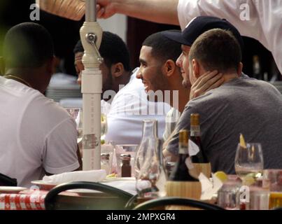 EXCLUSIVE!! Canadian actor and Grammy-nominated recording artist Drake (aka Aubrey Drake Graham) enjoys a meal with friends on Miami Beach while celebrating his 24th birthday during a trip to Miami. He was honored at a birthday bash sponsored by Grey Goose Vodka over the weekend, where he was named a Grey Goose Rising Icon. Drake's first studio album, 'Thank Me Later,' was released on June 15 and debuted at number one on the Billboard 200 chart. Miami Beach, FL. 10/25/10. Stock Photo