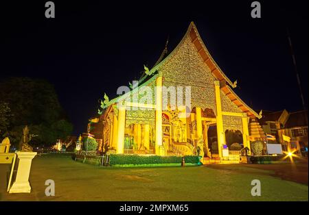 The Main Viharn Hall (Phra Viharn Luang) of Wat Chedi Luang in gold evening illumination against the dark sky, Chiang Mai, Thailand Stock Photo