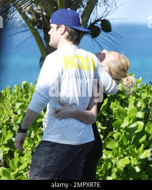 Exclusive!! Actress and Singer Hilary Duff and her hockey player boyfriend, Mike Comrie, enjoy an affectionate cuddle to keep warm during a stroll in the blustery ocean breeze . The couple jetted out of LA for a New Year vacation together at a luxury resort in the Caribbean. Duff's strappy sandals revealed a 'Let It Be' tattoo.  Caribbean 01/22/09 Stock Photo