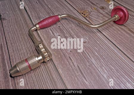 non-electric old hand drill on a wooden table Stock Photo