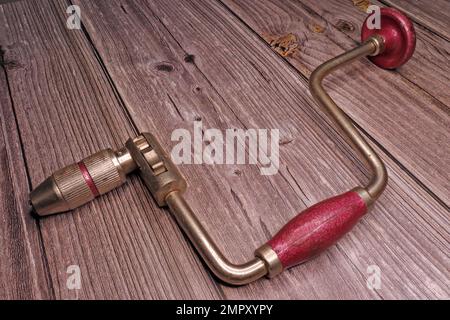 antique chrome and pink hand drill on a workbench Stock Photo