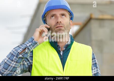 serious builder men in white helmet on the phone Stock Photo