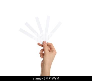 Woman holding perfume testing strips on white background, closeup Stock Photo