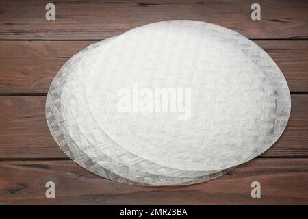 Sheets of dry rice paper on wooden table Stock Photo