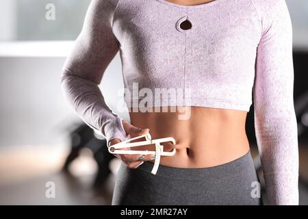 fitness trainer nutritionist measure female body fat percentage with  caliper Stock Photo - Alamy