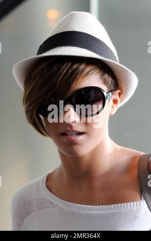 EXCLUSIVE!! Frankie Sandford of the UK girl group The Saturdays looks casual but chic in a white hat, revealing white top and jeans as she totes along her luggage and a Victoria's Secret shopping bag at a local luxury hotel. The Saturdays are currently in town shooting a new music video. Los Angeles, CA. 4/8/11. Stock Photo