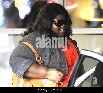 Actress Gabourey Sidibe, best known for her role in the award-winning film 'Precious: Based on the Novel Push by Sapphire', makes a swift exit from her London hotel to a waiting car. London, UK. 05/27/10.       . Stock Photo