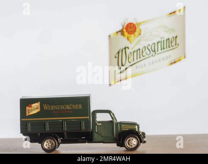 In this photo illustration, a model of a truck with an inscription Wernesgruner  on the background of the company logo on the monitor screen. The Wern Stock Photo