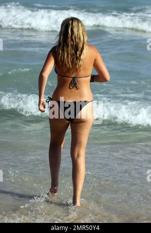 EXCLUSIVE!! Playboy Model, Josie Goldberg, dons a sparkling silver bikini during a day on the beach. Josie, who is currently in town to see a specialist doctor about her keloid scar, also took a dip in the ocean after which her bandaid dislodged to reveal the scar. Miami Beach, FL. 1/2/11. Stock Photo