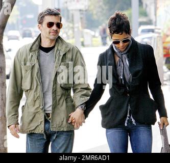 In a nice black ruffled jacket and jeans Halle Berry holds hands with boyfriend Olivier Martinez, who looked hunky in a casual green jacket, grey shirt and jeans, as they arrive for brunch at Susina Bakery and Cafe. Los Angeles. 04/10/11. Stock Photo