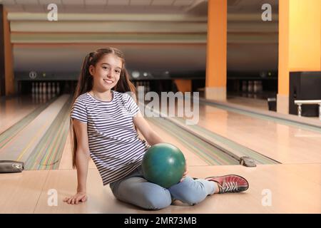 Preteen girl with ball in bowling club Stock Photo