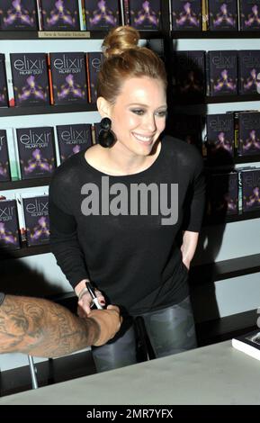 Wearing a black top and camouflage patterned leather pants, actress Hilary Duff delights a huge crowd of fans by signing copies of her new book 'Elixir' at Books & Books in the Bal Harbor Shops in Bal Harbor, FL. 10/15/10. Stock Photo