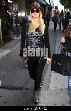 Wearing little makeup, a leopard-print hat and a black outfit, Paris Hilton takes her new 'BFF' Brooke Mueller out for a day of shopping. The duo, who are currently working on an unnamed reality television project, stopped in at a number of boutiques, including Alice and Olivia and Diavolina and Brooke carried a number of bags, while Paris carried nothing. Mueller, whose divorce from Charlie Sheen was finalized earlier this year, has been seen out and about with Hilton several times recently bringing up questions about her continuing sobriety. But, according to reports, Mueller, 33, insists sh Stock Photo