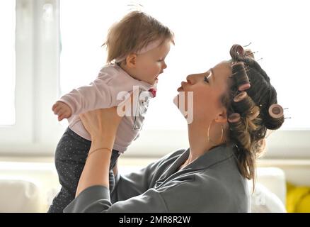 Mother with curlers in her hair, cuddling with daughter, infant, toddler, girl, 5 months, Baden-Württemberg, Germany, Europe Stock Photo