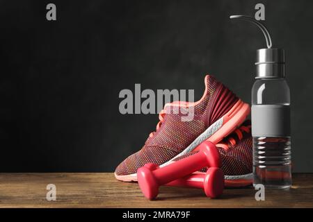 Gym equipment and accessories on floor against dark background. Space for text Stock Photo