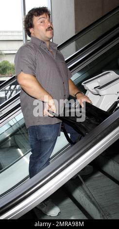 EXCLUSIVE!! Actor and funnyman Jack Black carries along an infant's car seat as he arrives for a flight at LAX. Black, who made faces for photographers as he ascended an elevator, is set to star alongside Matthew McConaughey, Shirley MacLaine and Rip Torn in the new black comedy 'Bernie.' The movie is based on a true story and tells the tale of a small-town funeral home director in Texas. Los Angeles, CA. 10/3/10. Stock Photo