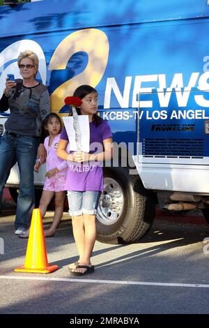 Fans and friends gather outside the Jackson family compound to leave flowers and gifts and pay their respects as the family arrives from UCLA Medical Center where Michael Jackson was pronounced dead after suffering from cardiac arrest this afternoon. Encino, CA. 6/25/09. Stock Photo