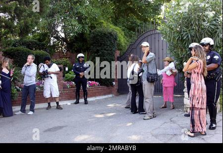 Fans and friends gather outside the Jackson family compound to leave flowers and gifts and pay their respects as the family arrives from UCLA Medical Center where Michael Jackson was pronounced dead after suffering from cardiac arrest this afternoon. Encino, CA. 6/25/09. Stock Photo