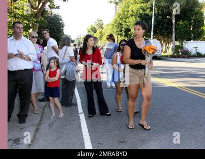 Fans and friends gather outside the Jackson family compound to leave flowers and gifts and pay their respects as the family arrives from UCLA Medical Center where Michael Jackson was pronounced dead after suffering from cardiac arrest this afternoon. Encino, CA. 6/25/09. Stock Photo